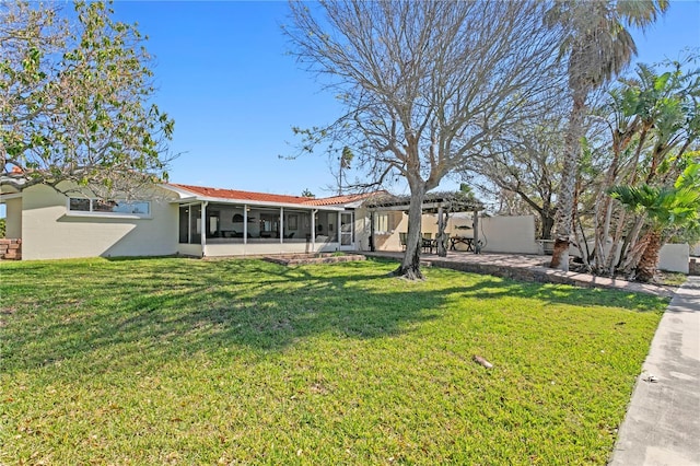 back of house with a sunroom, a patio, and a yard