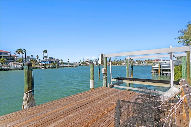 dock area with a water view and boat lift