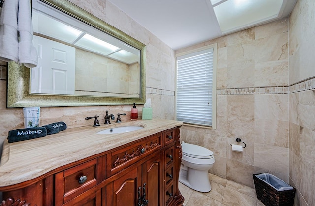 bathroom with tile walls, toilet, and vanity