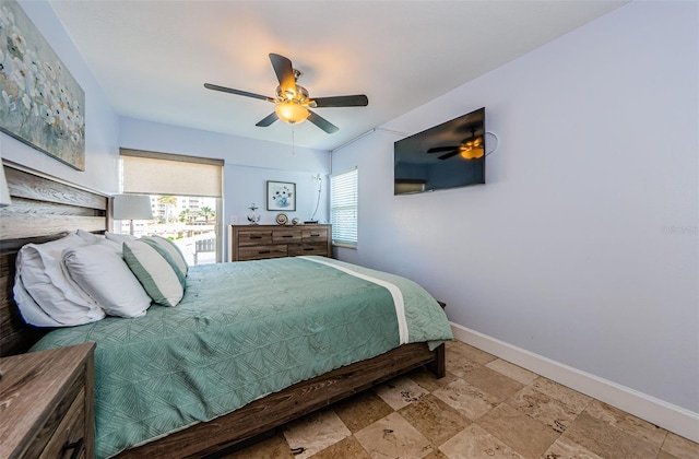 bedroom with stone finish floor, ceiling fan, and baseboards