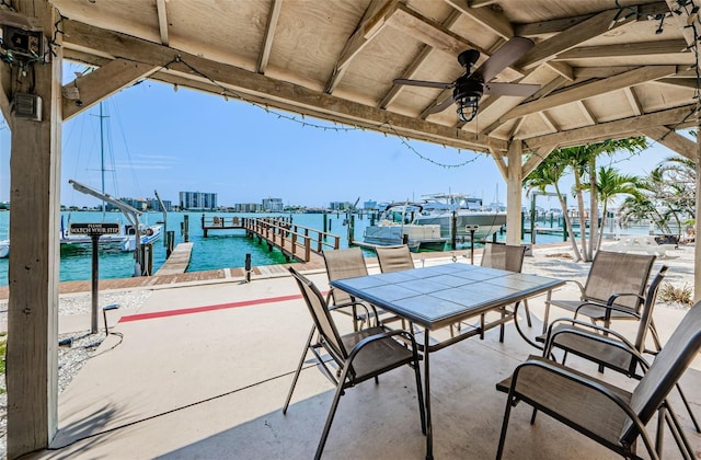 view of patio with a view of city, a dock, a water view, and a ceiling fan