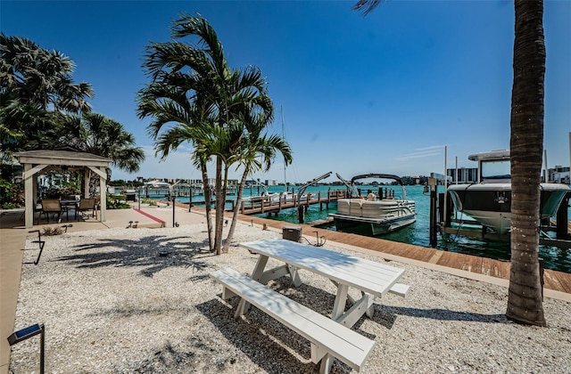 dock area with a gazebo, a water view, and boat lift