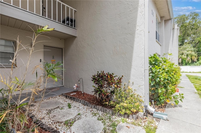 view of home's exterior with stucco siding and a balcony