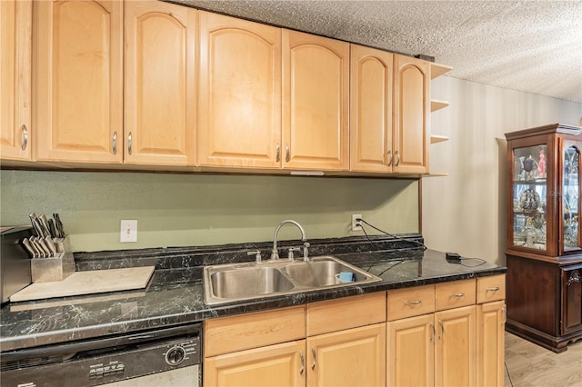 kitchen with a sink, dishwashing machine, dark countertops, and light brown cabinetry