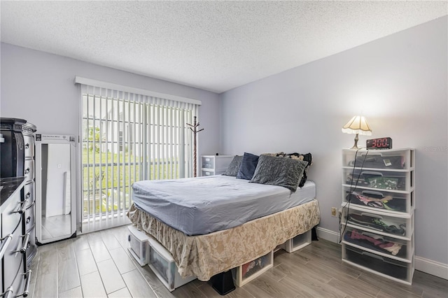 bedroom with baseboards, a textured ceiling, light wood-style flooring, and access to outside