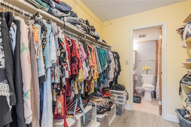 walk in closet featuring visible vents and wood finished floors