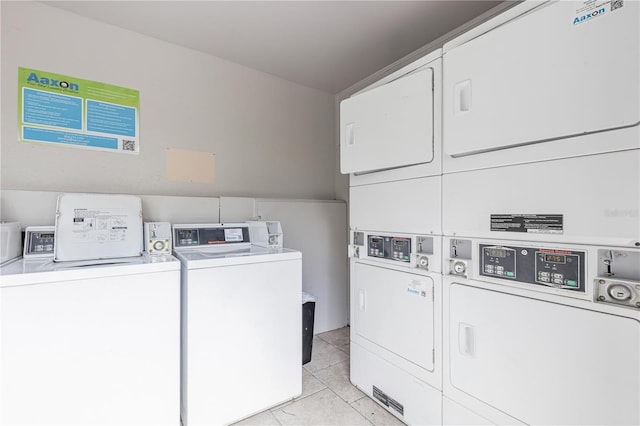 community laundry room with light tile patterned floors, stacked washer and clothes dryer, and washer and clothes dryer