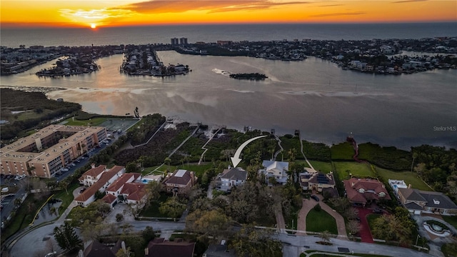 aerial view at dusk featuring a water view