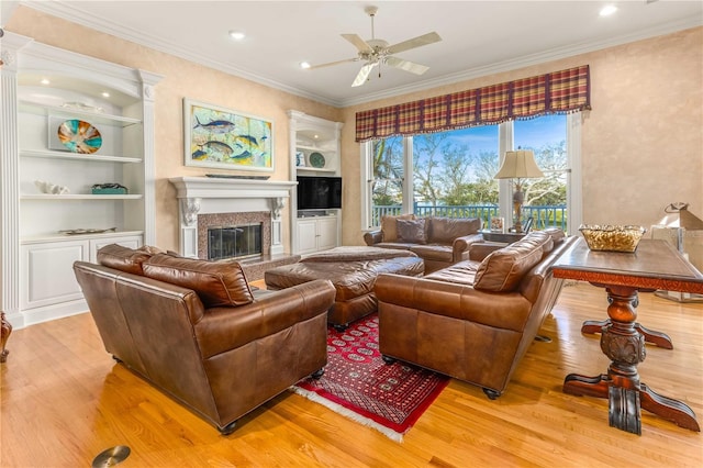 living room featuring crown molding, built in features, and light wood-style floors