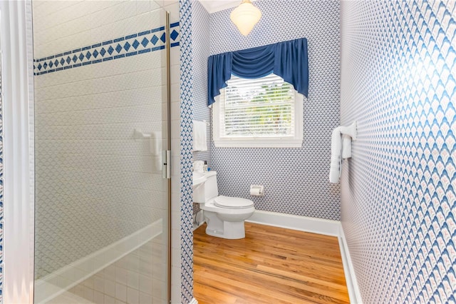 full bathroom featuring baseboards, toilet, wood finished floors, and a shower stall