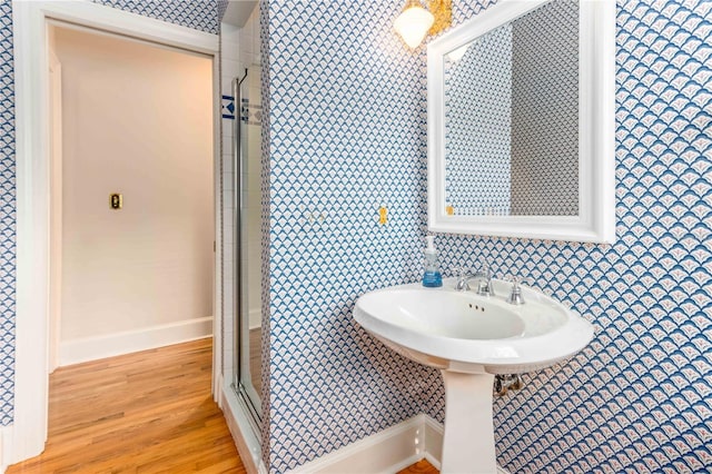 full bath with baseboards, wood finished floors, and a shower stall