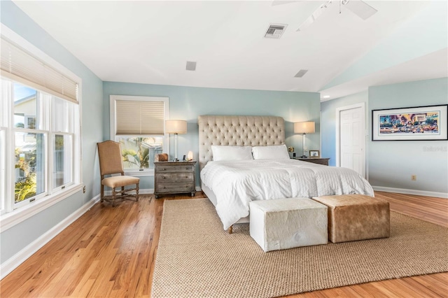 bedroom with lofted ceiling, light wood-style flooring, and multiple windows