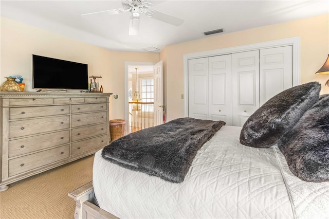 carpeted bedroom with a ceiling fan, visible vents, and a closet