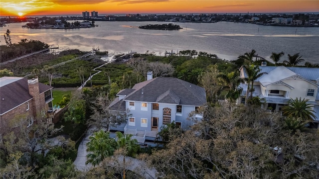 aerial view at dusk featuring a water view