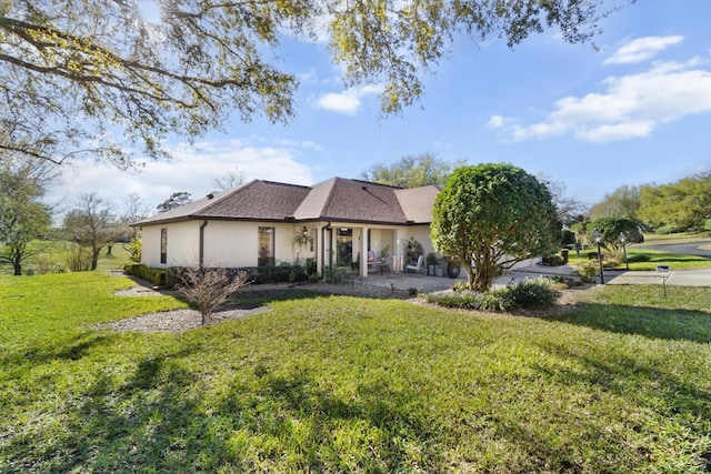 view of front of house with stucco siding and a front yard