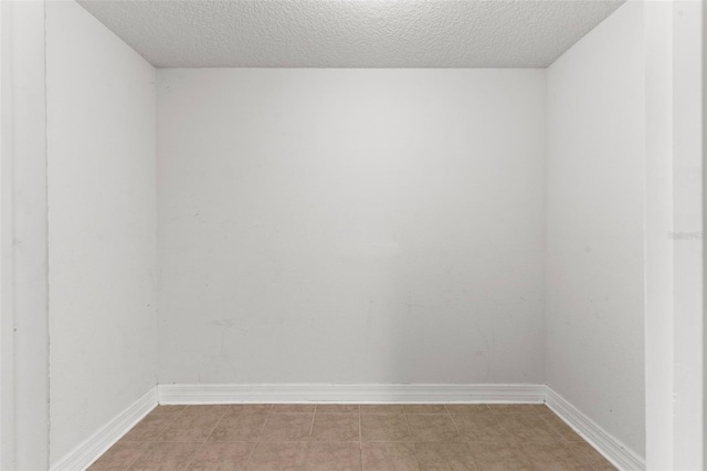 empty room with baseboards and a textured ceiling