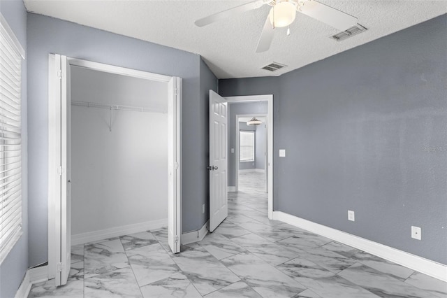 unfurnished bedroom with a closet, visible vents, marble finish floor, and baseboards