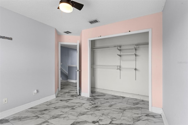 unfurnished bedroom featuring a closet, visible vents, marble finish floor, and baseboards