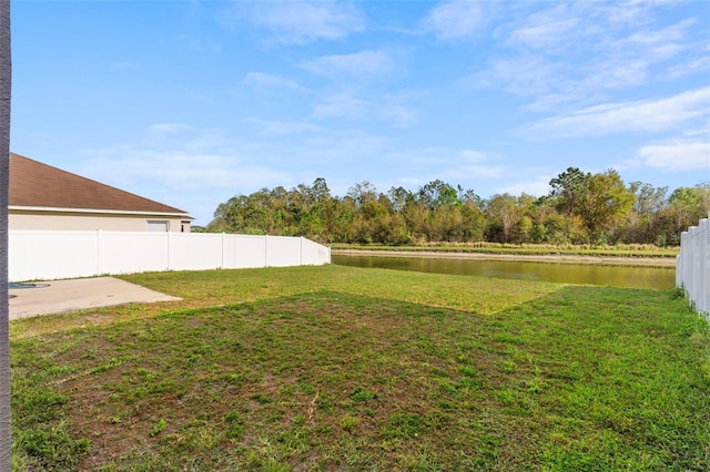 view of yard with a patio area, a water view, and fence