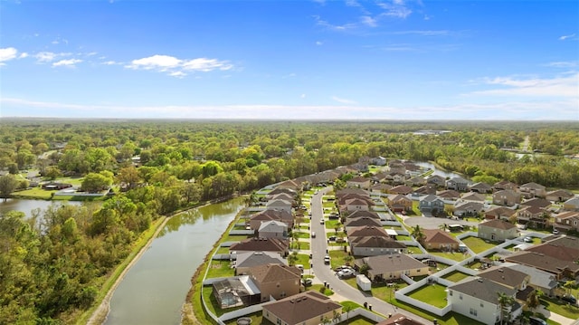 drone / aerial view featuring a forest view, a residential view, and a water view