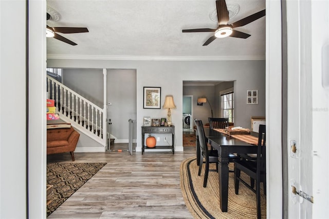 dining room featuring ornamental molding, wood finished floors, stairway, baseboards, and ceiling fan