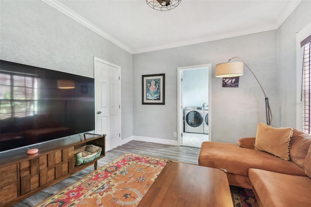 living room with baseboards, wood finished floors, crown molding, and washing machine and clothes dryer