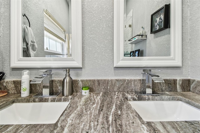 bathroom featuring vanity and a textured wall