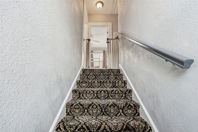 stairs with baseboards and a textured wall