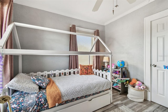 bedroom with crown molding, a ceiling fan, and wood finished floors