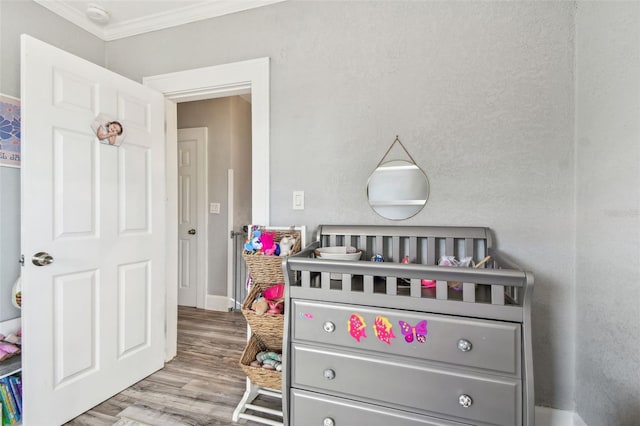 bedroom with crown molding and wood finished floors