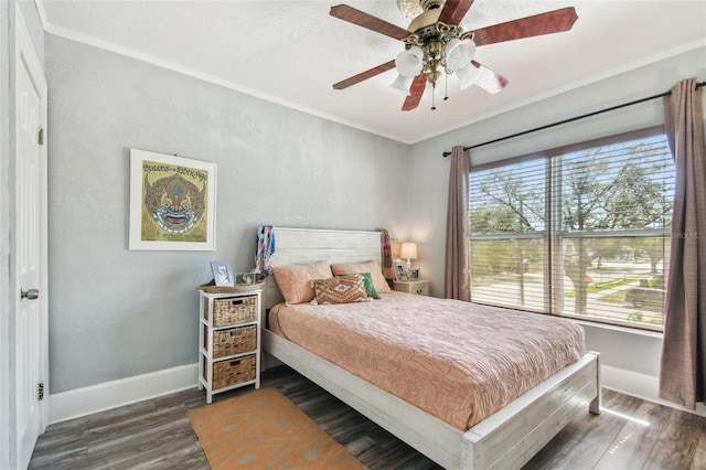 bedroom featuring ceiling fan, baseboards, wood finished floors, and ornamental molding