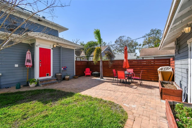 view of patio featuring entry steps, outdoor dining area, and fence