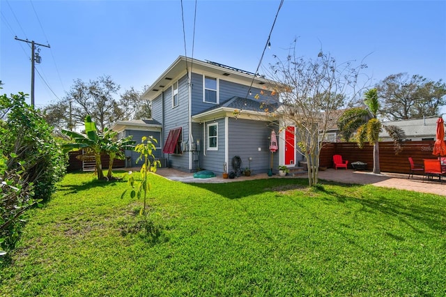 back of house featuring a patio, a lawn, entry steps, and fence