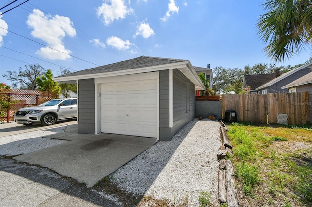 detached garage featuring fence