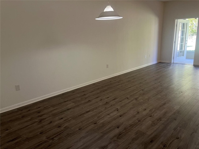 unfurnished room featuring dark wood-style flooring and baseboards