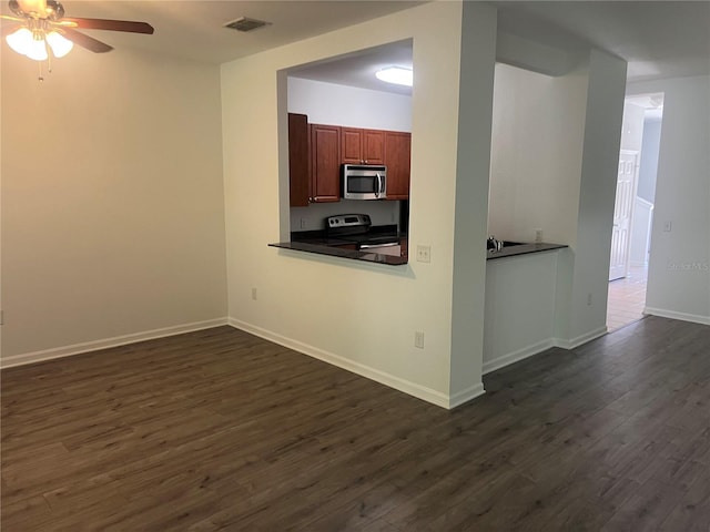 kitchen featuring baseboards, visible vents, a ceiling fan, dark wood finished floors, and stainless steel appliances