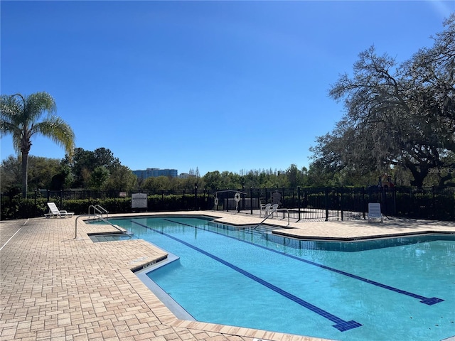 pool with a patio area and fence