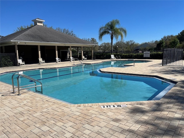 pool featuring fence and a patio