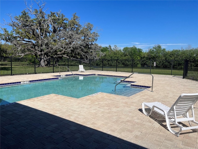 community pool with a patio and fence