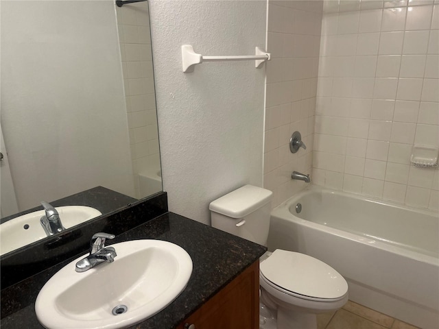 bathroom with a textured wall, bathtub / shower combination, vanity, and toilet