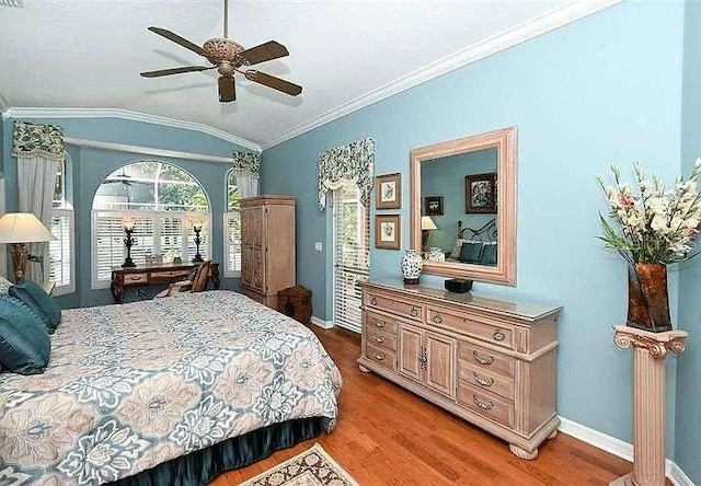 bedroom with baseboards, a ceiling fan, ornamental molding, wood finished floors, and vaulted ceiling