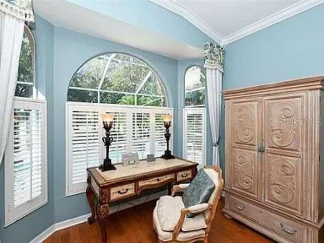 office area with baseboards, wood finished floors, and crown molding