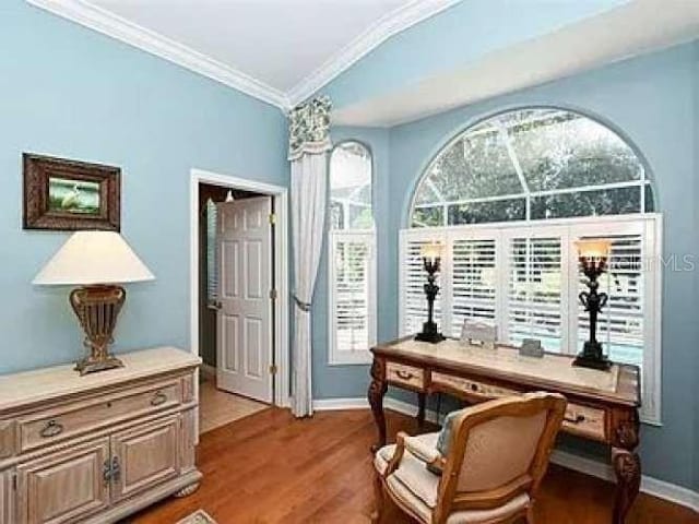 office area with baseboards, wood finished floors, and crown molding