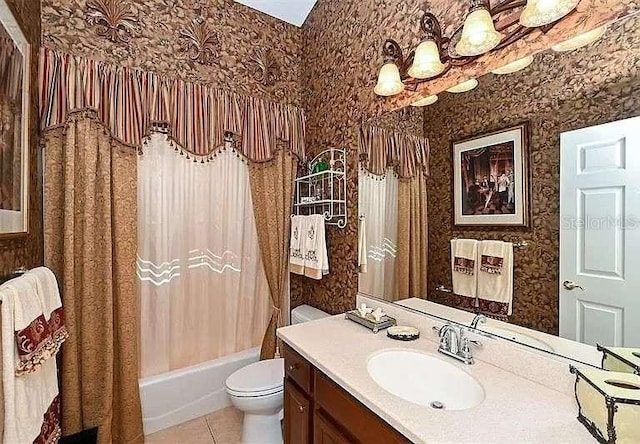 bathroom with vanity, toilet, and wallpapered walls