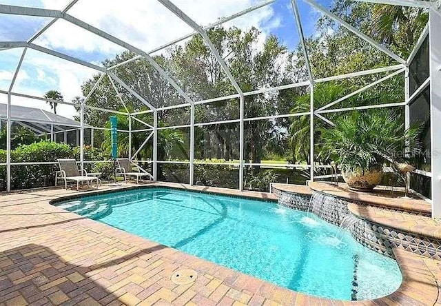 pool with a patio and glass enclosure