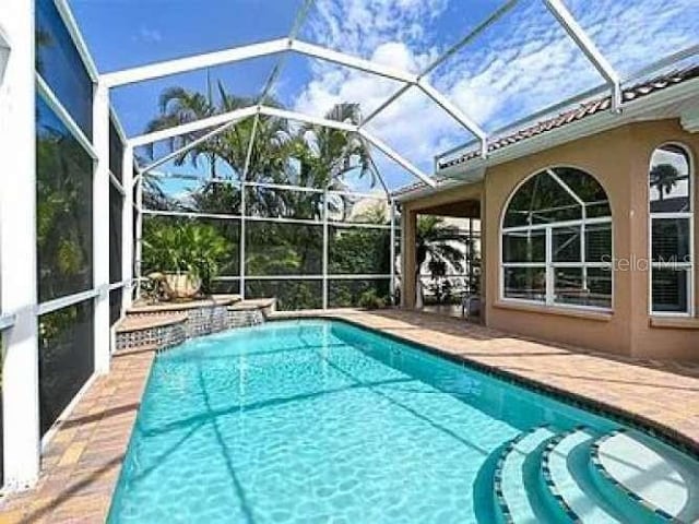 outdoor pool with a patio area and a lanai