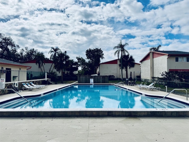 community pool featuring a patio and fence