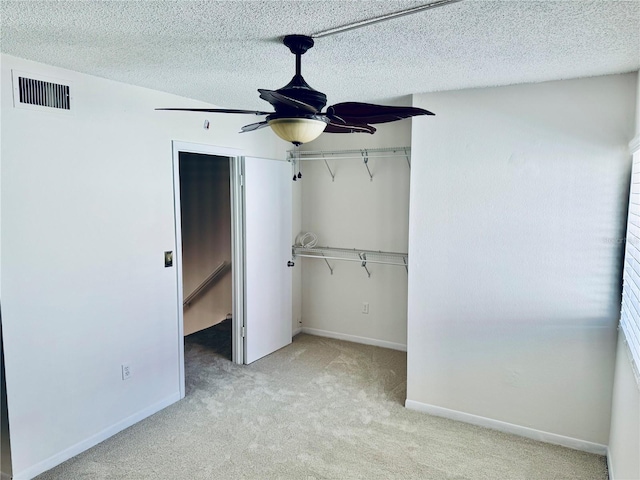 unfurnished bedroom with visible vents, baseboards, carpet floors, a closet, and a textured ceiling