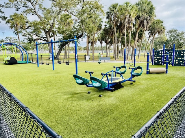 surrounding community with fence, playground community, and a lawn