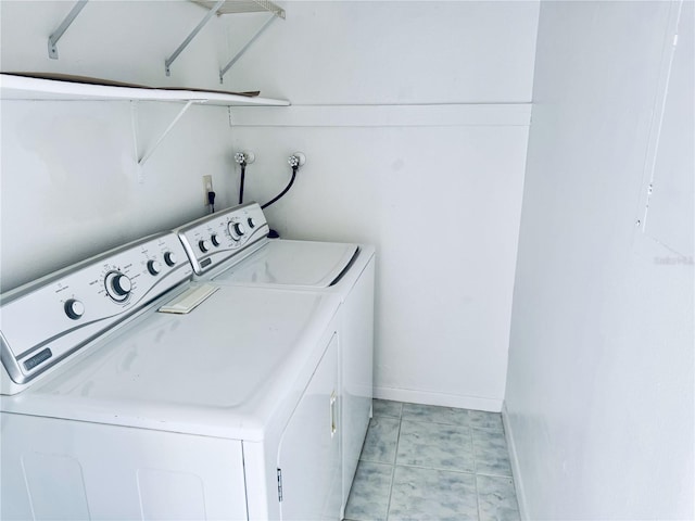 clothes washing area featuring laundry area, baseboards, and washing machine and clothes dryer